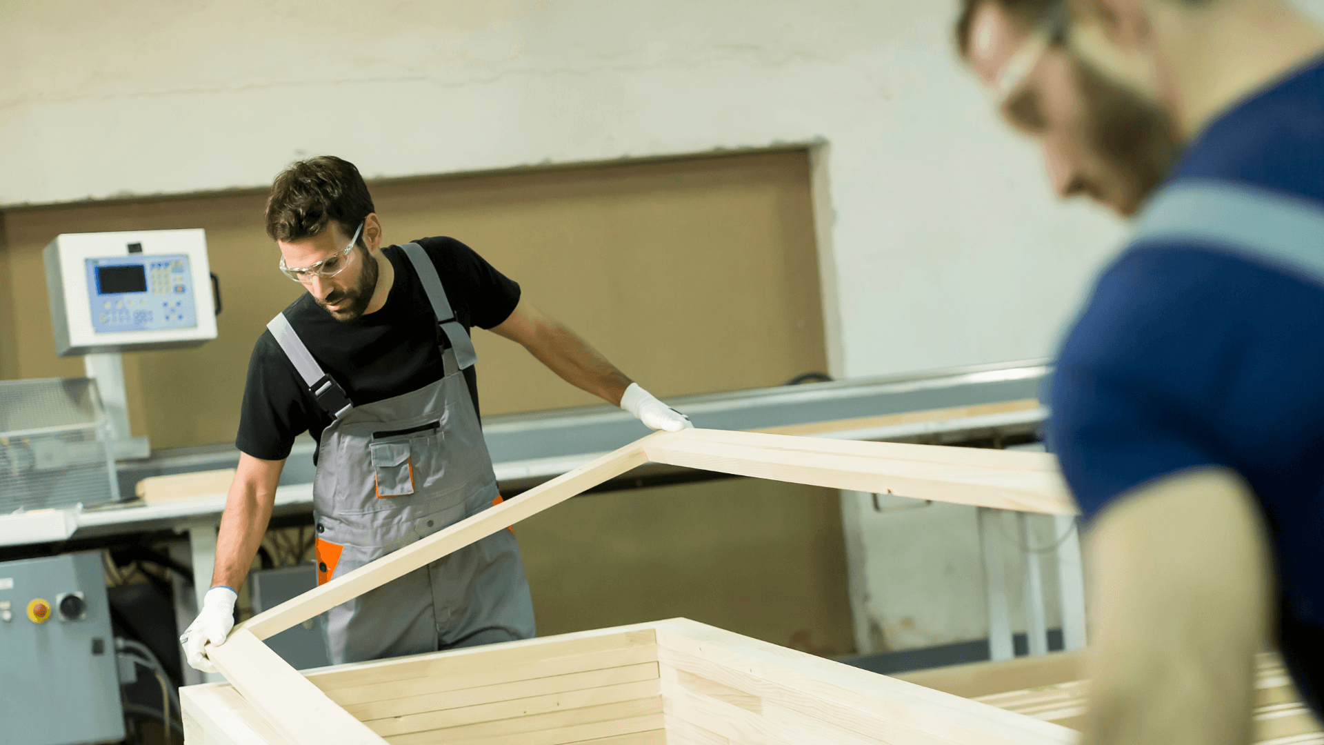 Junge männliche Arbeiter arbeiten in einem Möbelproduktionsunternehmen.